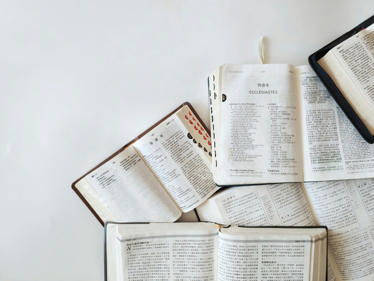 Open books in several languages spread across a table