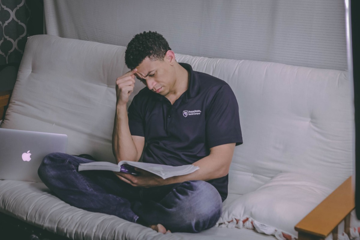 Person thinking while reading a book